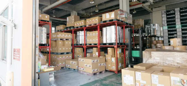 東和グラビヤ印刷株式会社の出荷倉庫に並ぶ製品の段ボールとラック