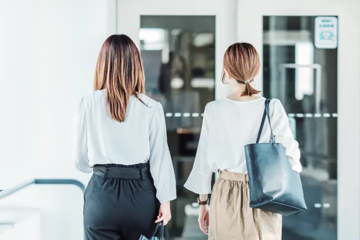 退社時にオフィスの出口を歩く女性社員の後ろ姿