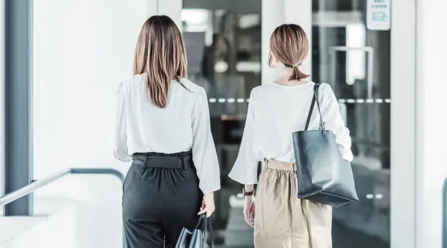 退社時にオフィスの出口を歩く女性社員の後ろ姿