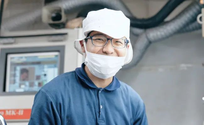 作業場で笑顔を見せるオペレーター社員のポートレート