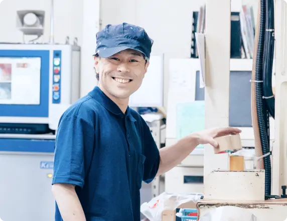 仕事風景グラビア印刷機の前で笑顔を見せる現場スタッフ