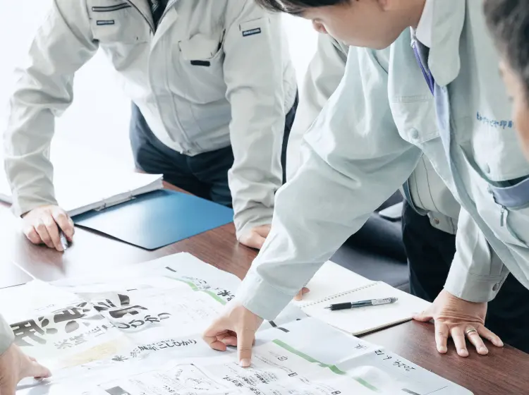 東和グラビヤ印刷株式会社の社員が食品パッケージの印刷見本を確認しながら打ち合わせを行う様子